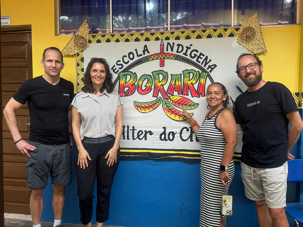 Vier Personen stehen vor dem Schild der Escola Indigena Borari in Alter do Chao in Brasilien