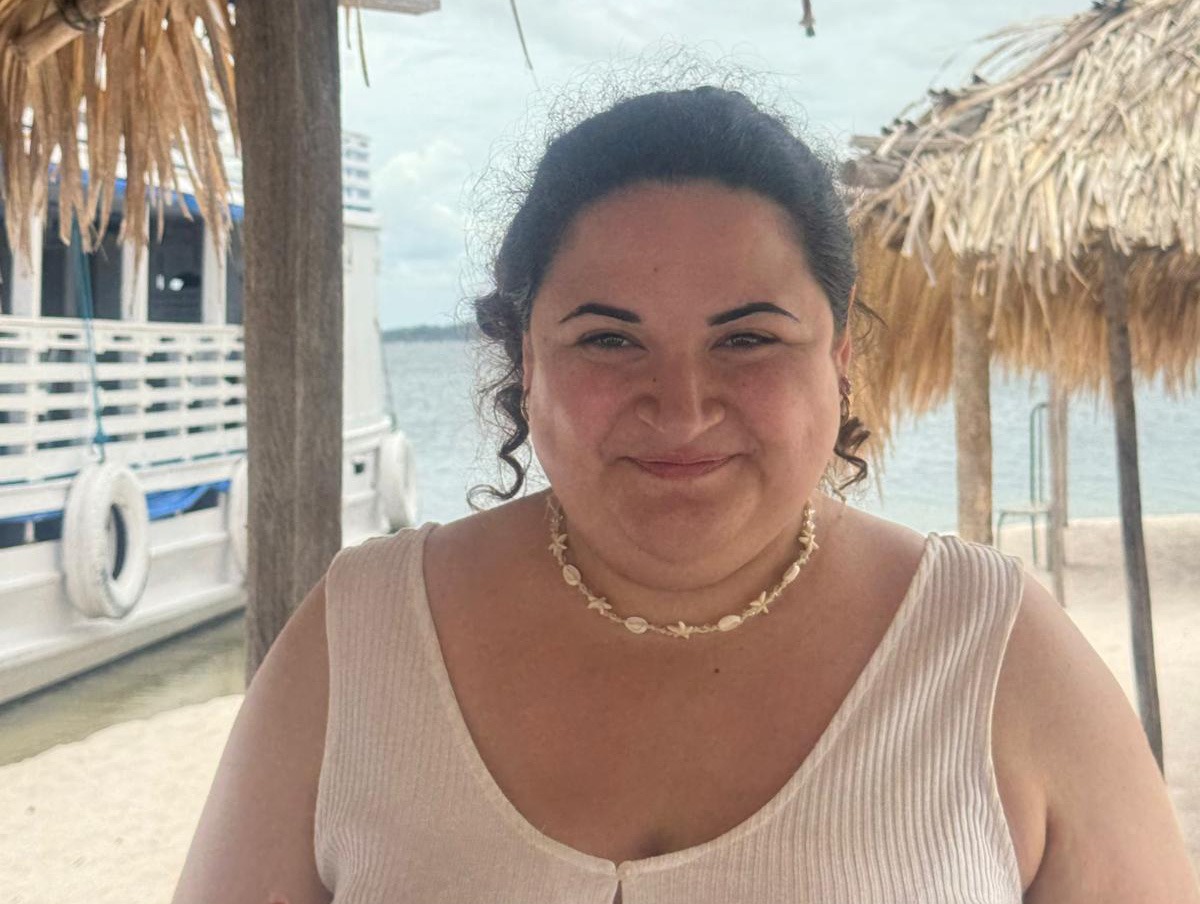 Portrait von Diana unter einem Palmdach am Wasser in Brasilien